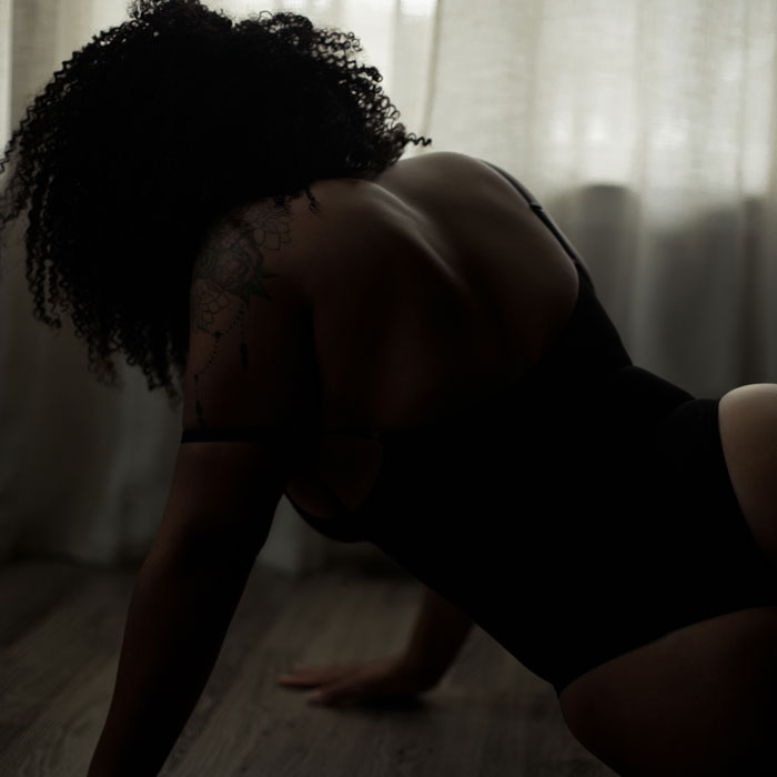 woman-posing-on-the-floor creating beautiful angles with dark and moody natural light from the window